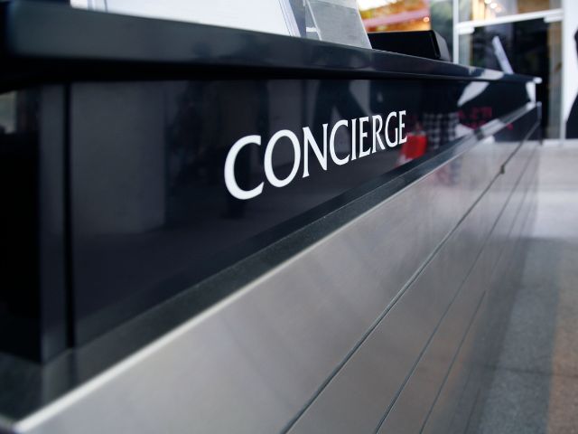 Sign on a wood panel that reads "Concierge".
